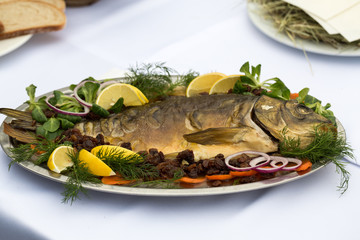 carp  with lemon, dill and raisins on plate