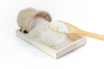 Fototapeta na wymiar White long rice in a sack and wooden scoop isolated on white background