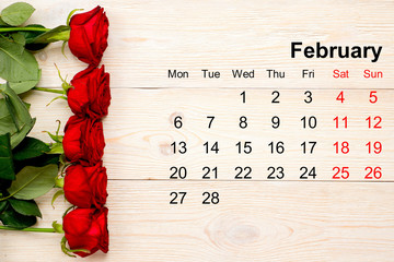 February 2017 calendar with red roses on white table