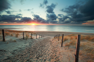 sand path to sea beach at sunset - obrazy, fototapety, plakaty