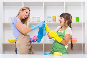 Happy mother and her daughter enjoy cleaning and having fun together.