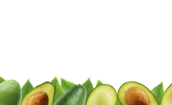 Fresh avocado with leaves on white background. Halves of fresh avocado at border of image with copy space for text. Top view. Vegetarian or healthy eating.