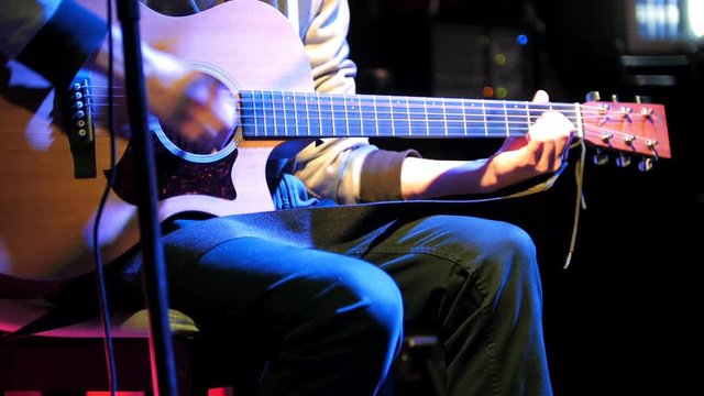 Guitarist plays concert acoustic guitar in night club
