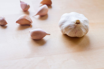 A selective focus of white garlic and pink garlic cloves on wooden table, the preparation for cooking, garlic is ingredient for Asian style of cooking