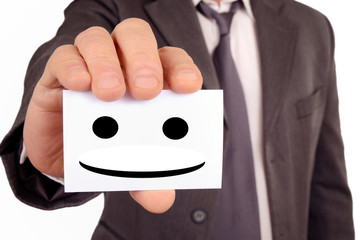 Homme tenant une carte avec un visage souriant dessiné dessus