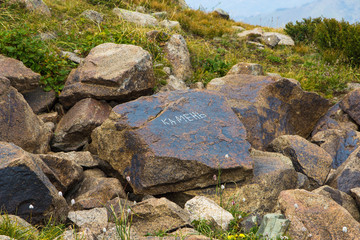 Fototapeta na wymiar Stone with russian text. Mountain landscape in Kazakhstan, near