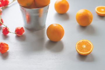A beautiful yellow color of oranges, orange slices, orange flower laying on light blue rustic wooden table, oranges fruit with high vitamin C, vintage style of color tone