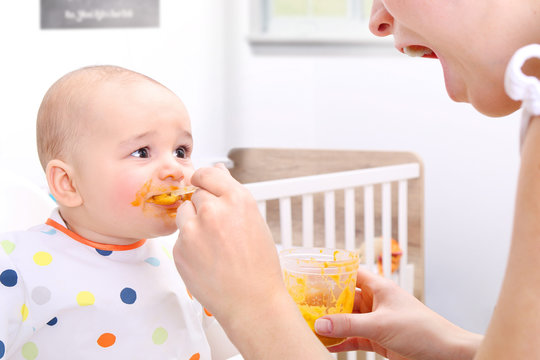 Mother feeding her baby solids