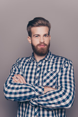 Obraz premium portrait of bearded thinking stylish young man crossing hands a