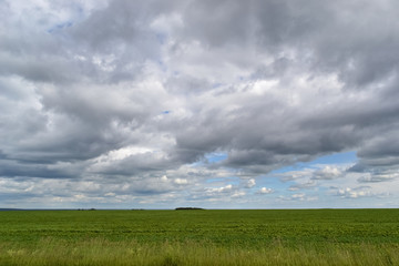 Blue sky and clouds over green field