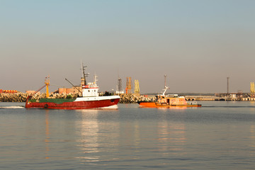 Fototapeta premium Red fishing boat entering the port of Ventspils
