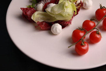 Salad, mozzarella, cherry tomatoes, white plate bio vegetables, rustic food, homemade food 