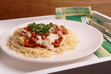The best spaghetti bolognese with parmesan and parsley on a dark background

