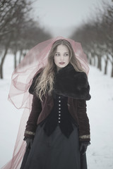 girl in a red veil on the snow in the winter