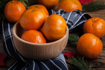 Fresh oranges in wooden bowl.