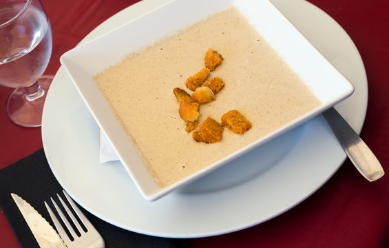 Creamy agaric soup served with sippets