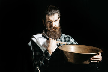 Bearded man shaves with razor