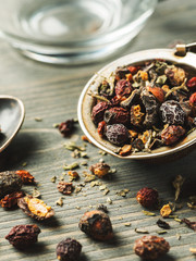 Herbal tea in metal stainer with silver spoon