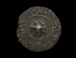 Ancient bronze islamic coin with lion head in the center isolated on black