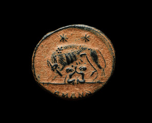 Ancient roman commemorative coin with image of Romulus, Remus and wolf isolated on black