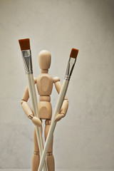 Wooden mannequin with paintbrush