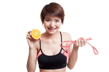 Asian healthy girl on diet with orange fruit and measuring tape.