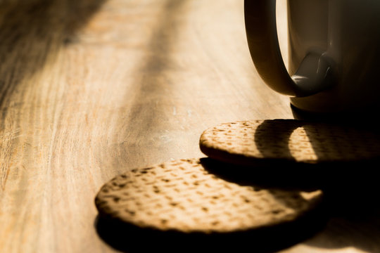 Cup and biscuits on a wooden background. Close up picture. Natural daylight. 
