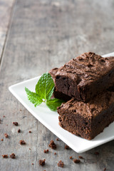 Chocolate brownie portions on wooden background
