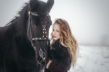 Obraz premium a girl with a horse in a field in winter