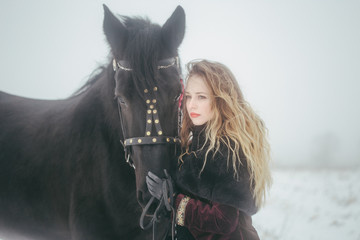 a girl with a horse in a field in winter