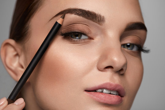 Beautiful Woman Contouring Eyebrows With Pencil. Beauty