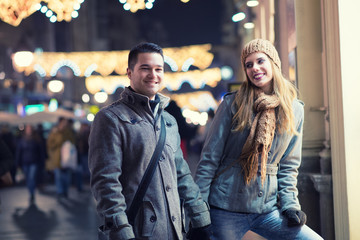 Young lovers enjoy on the street at night in the city, the street lights, romance.Under exposed photo