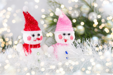 Two toy snowman with festive background