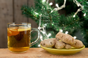 Ginger tea in a cup on wooden background