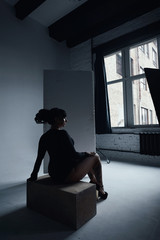 curvy raven haired woman with dreadlocks poses in loft studio