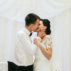 Newlywed bride & groom first romantic kiss at wedding reception