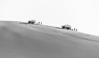 Tourists travel through the dunes in the Atacama Desert - Oasis of Huacachina, Peru, South America (black and white)