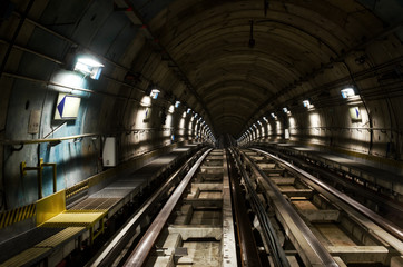 Fototapeta na wymiar Metro subway of Turin (Italy), dark tunnel with rails seen from the train