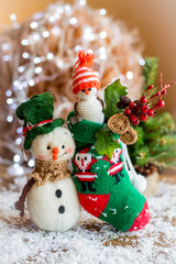 Handmade yarn snowman holding gifts in a sock, boot.