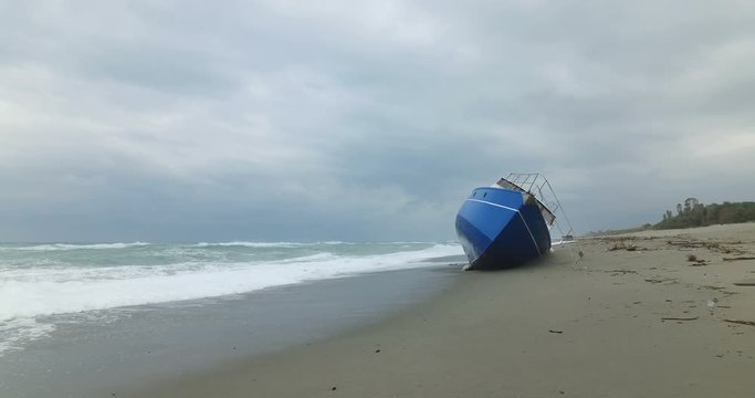 Barca degli immigrati arenata sulla costa dopo una forte tempesta in mare. 