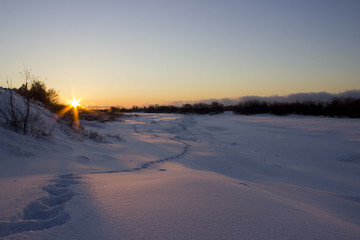 Winter sunset. Village at sunset.