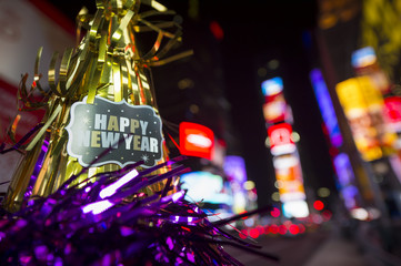 Happy New Year message with celebration tinsel flying on novelty party hat in Times Square, New...