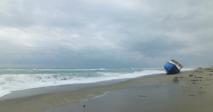 Barca degli immigrati arenata sulla costa dopo una forte tempesta in mare. 