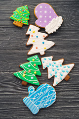 Celebrating New Year at home. Christmas ginger and honey cookies on gray wooden background. Fir tree, glove shape. Festive bakery top view, flat lay. Gingerbread with copy space.