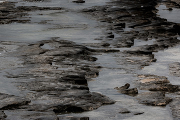 Dark rocks formations along the shoreline in western Galilee