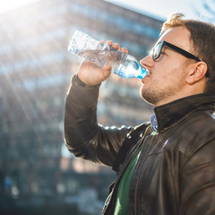 Man drinking water in the city