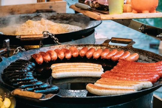Potatoes And Sausages Fried On A Frying Pan. Traditional Christmas Dish Of Street Food On Streets Of Europe