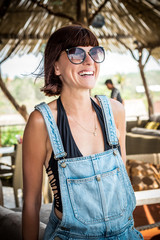 Close-up portrait of smiling female in the outdoor wooden bar near the Indian ocean, tropical island Bali, Indonesia, Asia.