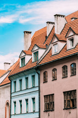 Riga Latvia. Mansard Tile Roof With Four Gable Fronted Dormer Windows On The Old Building Under Blue Sky
