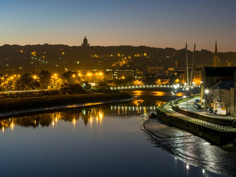 Lancaster City at dawn over River Lune with sunrise glow and street lights sparkling